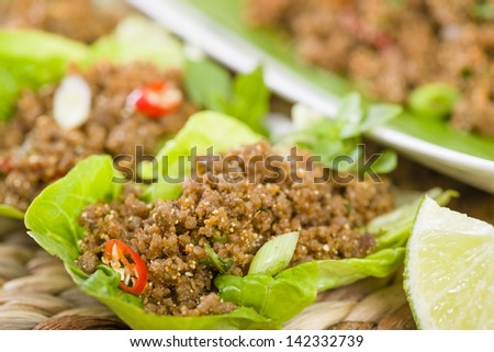 Larb - Lao minced beef salad with fish sauce, lime juice, roasted ground rice and fresh herbs served in lettuce leaves wraps.