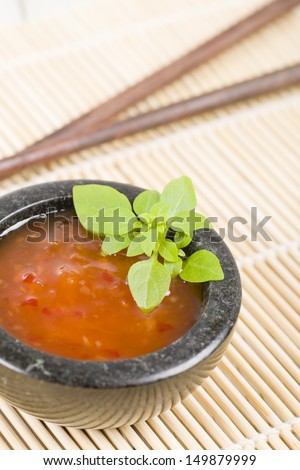 Sweet Chili Sauce - Asian style sweet chili sauce in a granite bowl garnished with basil.