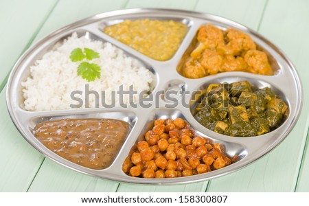 Thali - South Asian selection of vegetarian curries and rice served in a traditional dish. Taka dahl, gobi masala, palak paneer, chana masala and dahl makhani.