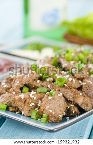 Bulgogi - Korean grilled marinated beef served with green chillies, garlic, ssamjang, kimchi and lettuce leaves.