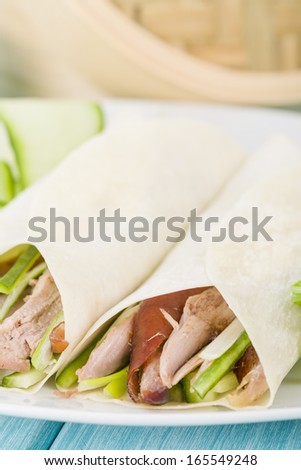 Peking Duck - Chinese roast crispy duck, cucumber and spring onions wrapped in pancakes served with hoisin sauce.