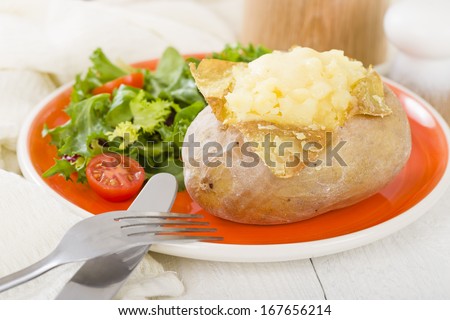 Jacket Potato - Baked potato topped with cheese and served with salad.