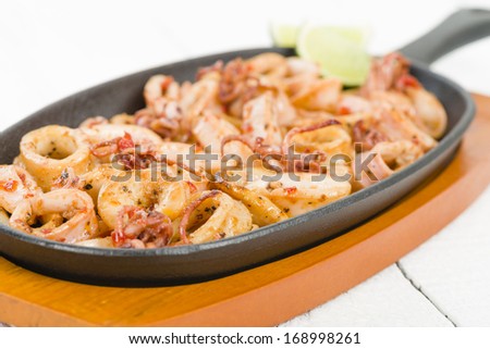 Fried Squid Rings - Fried squid rings with red pepper in a sizzle pan.