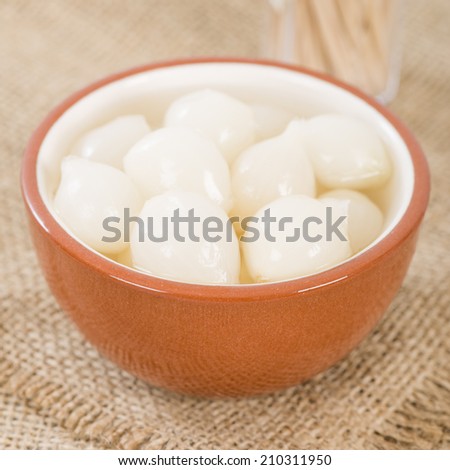 Silverskin Pickled Onions - Small onions pickled with vinegar and salt in a bowl.