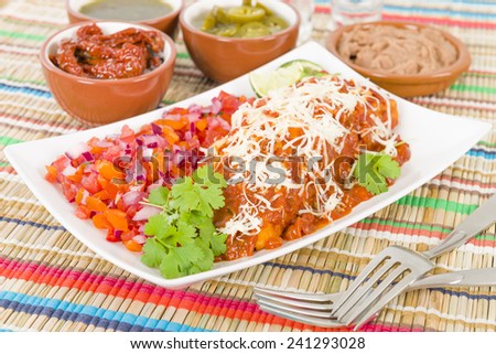 Chicken & Chorizo Enchiladas - Mexican soft tortilla filled with chorizo and chicken cooked in spicy tomato sauce. Served with salsa, refried beans and jalapenos.