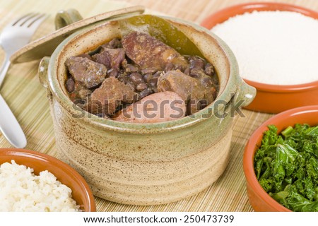 Feijoada - Brazilian beef, sausage, pork and black bean stew served with manioc flour, kale and white rice.