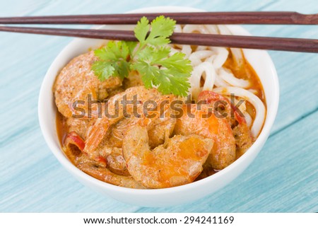 Thai Prawn Curry with Noodles - Thai red curry with prawns served with rice noodles in a white bowl.