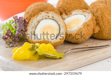 Scotch Egg - Hard-boiled egg wrapped in sausage meat, coated in breadcrumbs and deep-fried. Served with salad and piccalilli.