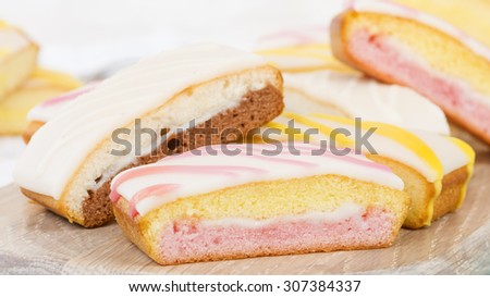 Cake Slices - Variety of colourful cake slices on a wooden board.