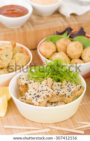 Party Food - Selection of prawn dishes on a wooden background. Prawn Toast, Prawn Popcorn, Butterfly Prawn and Prawn Goujons.