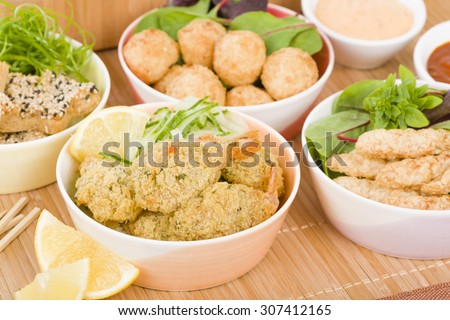Party Food - Selection of prawn dishes on a wooden background. Prawn Toast, Prawn Popcorn, Butterfly Prawn and Prawn Goujons.