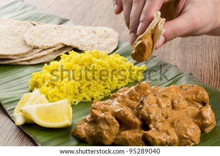 Butter Chicken & Lemon Rice - Indian butter chicken curry and lemon rice served with chapatis on a banana leaf.