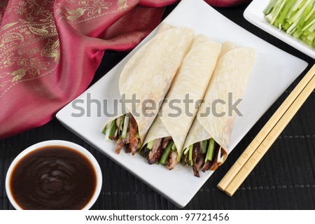 Peking Duck - Chinese roast duck served with cucumber, spring onion and hoisin sauce, wrapped in pancakes.