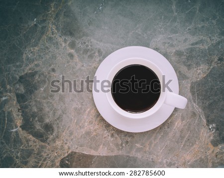 close of coffee cup on granite top, vintage style.