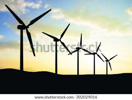silhouette view of wind turbine with burred sky background