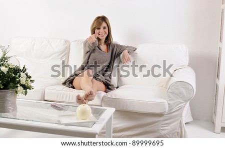 Young woman thumb up on the sofa