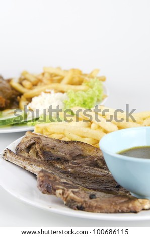 Closed up view of western food with lamb chop, salad,black pepper sauce and french fries.