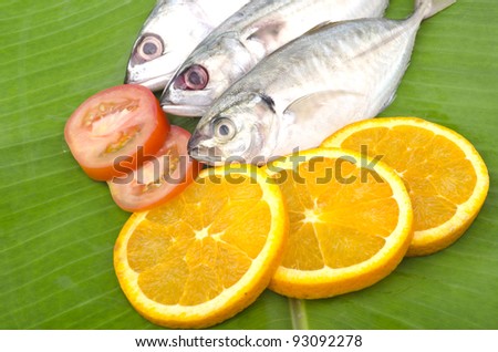 Closed up of fresh fish stacked on banana leaf as background.