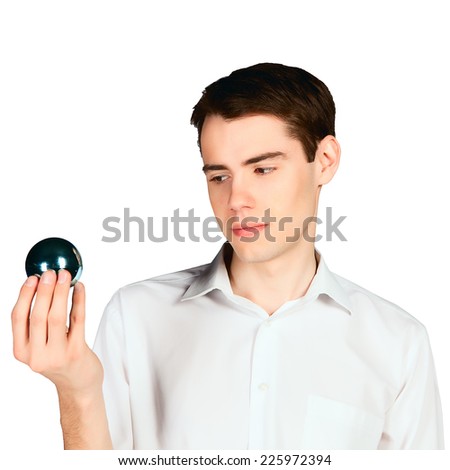 young man looks at mysterious shiny blue ball isolated on white background