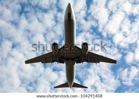 white plane with the gear against the blue sky, view from below