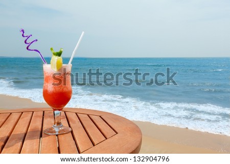 banana daiquiri cocktail with ice on the table against the background of sea and sky