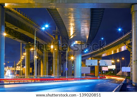 cityscape with road overpass in the lamplight with reflections on the asphalt