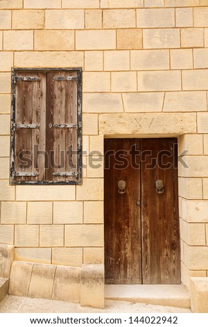 old wooden front door and window to the house in the Mediterranean