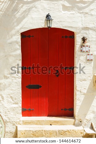 red wooden front door to the house in the Mediterranean