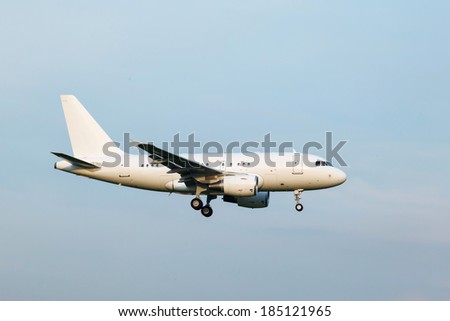 going to land a white passenger jet with landing gear on the background of blue sky, view from below