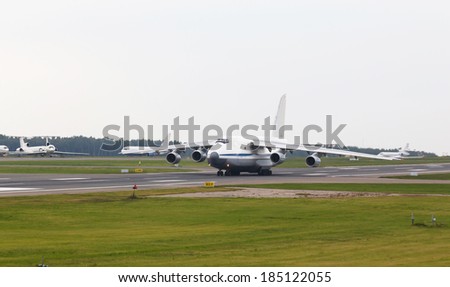 White heavy cargo jet with four engines take off in the airport