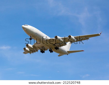 view from below on the white jet passenger aircraft with the gear on the background the blue sky
