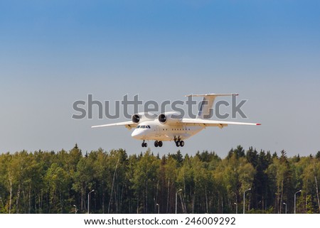 white jet passenger aircraft with the gear landing on blue sky background