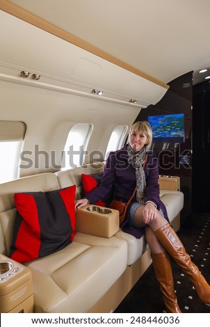 young beautiful woman in Luxury interior aircraft business aviation decorated table