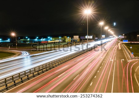 transport metropolis, traffic and blurry lights of cars on multi-lane highways and dense road traffic at night in Moscow