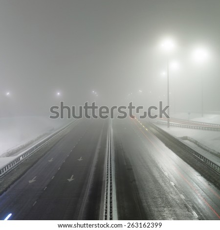 foggy winter night on the highway in the night the light of lanterns. Rosiiya, Moscow