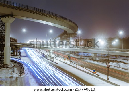 transport metropolis, traffic and blurry lights of cars on multi-lane highways and  road junction at night in Moscow
