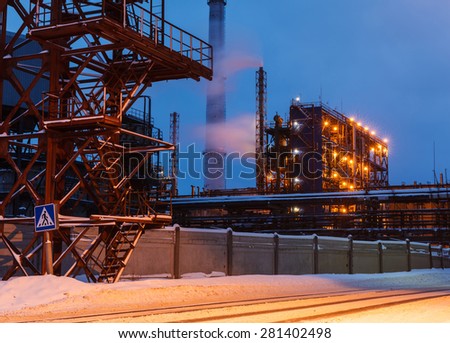 many pipes and smokestacks with industrial tower of metal on the chemical industry at night