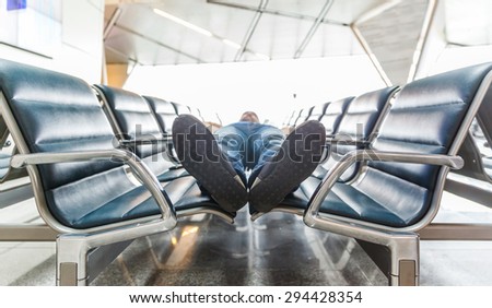 Young man sleeping at the airport while waiting for delayed flights