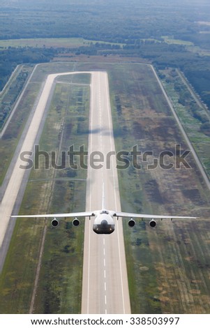 white jet cargo plane takes off from the runway on the background of airstrip