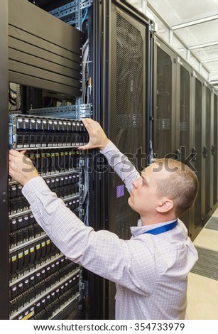 IT Engineer installs equipment in the rack in datacenter