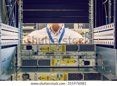IT Engineer installs equipment in the rack in datacenter