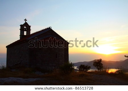 a small St. Sava church on the hill by the sea in the sunset