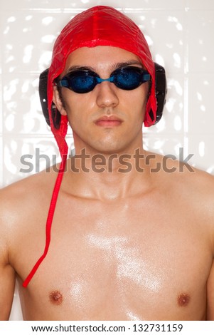 Male water polo player. In front of tile wall.