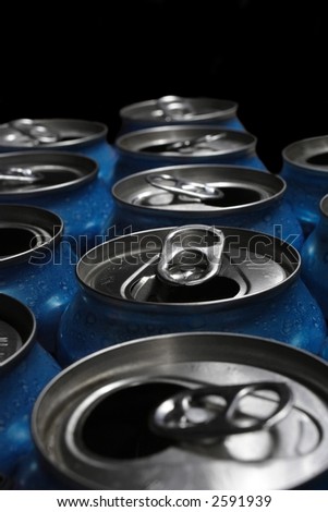 Numerous aluminum soda pop cans over black, open.