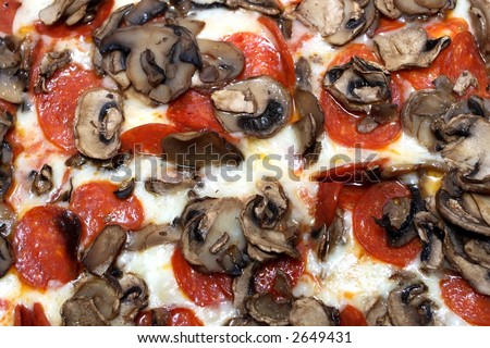 A pepperoni and mushroom pizza pie, isolated on white.