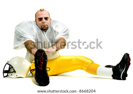 An American football player. Stretching before game.