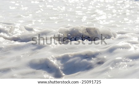 A layer of ice forms a skin over a field of snow.