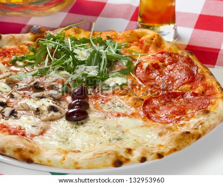 Quattro Stagioni (four seasons) pizza on a restaurant table. Studio shot