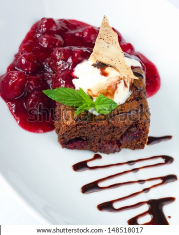 Chocolate brownie with vanilla ice-cream, cooked cherry and chocolate sauce