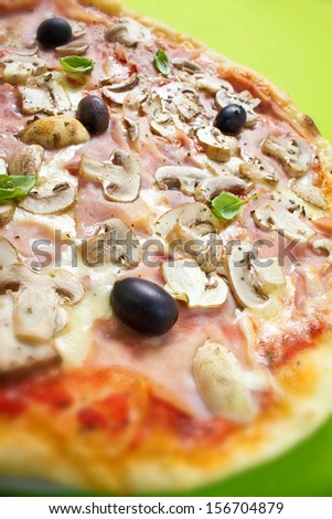 Rustic thin crust pizza with pelato sauce, mozzarella, ham, mushrooms, olives and fresh basil